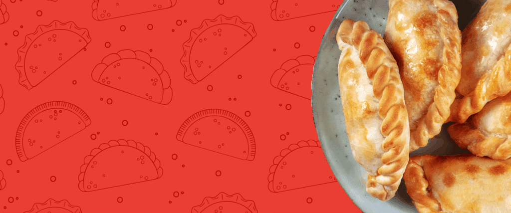 A plate of empanadas in front of a patterned background