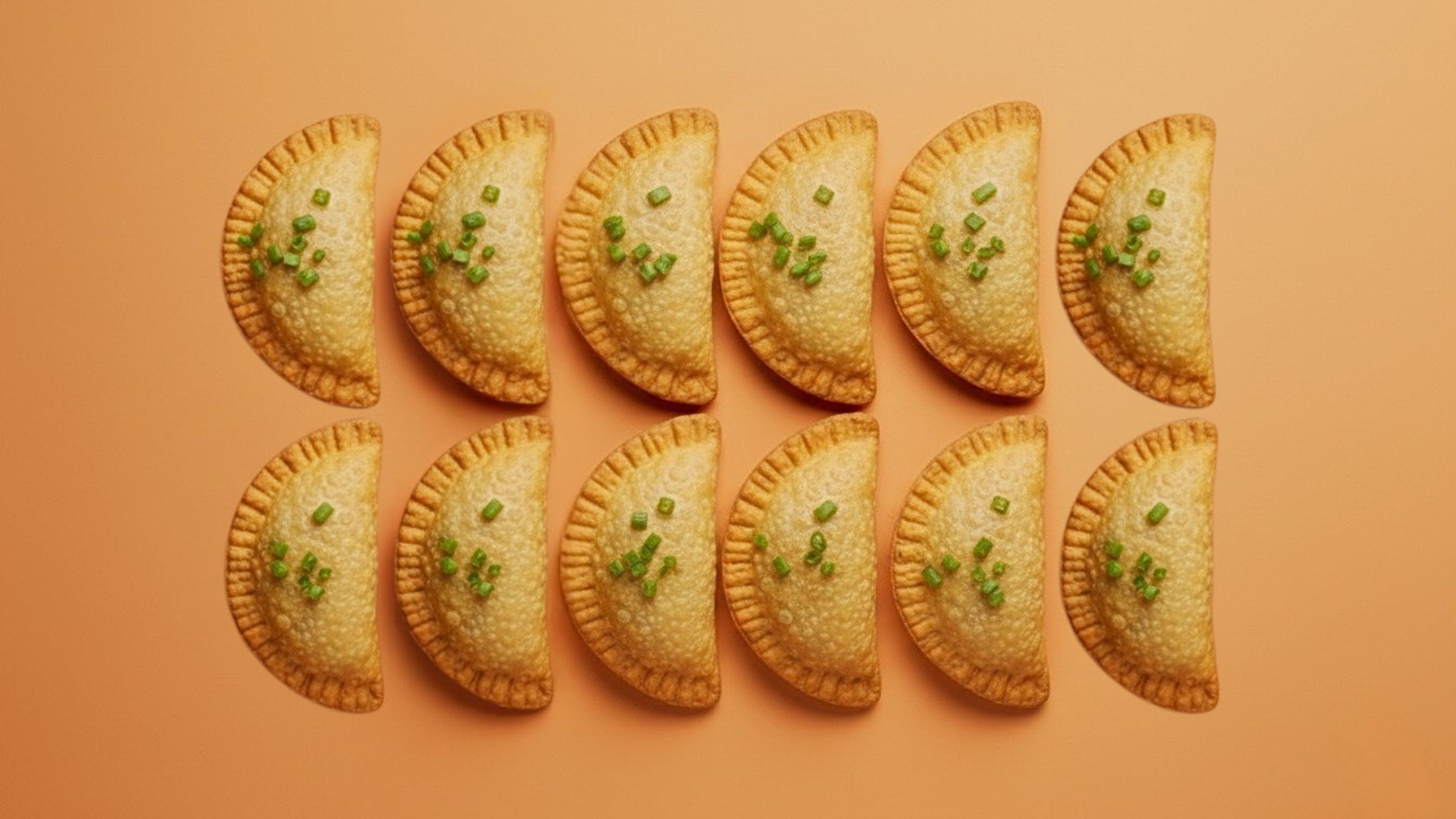 12 empanadas lined up on a table