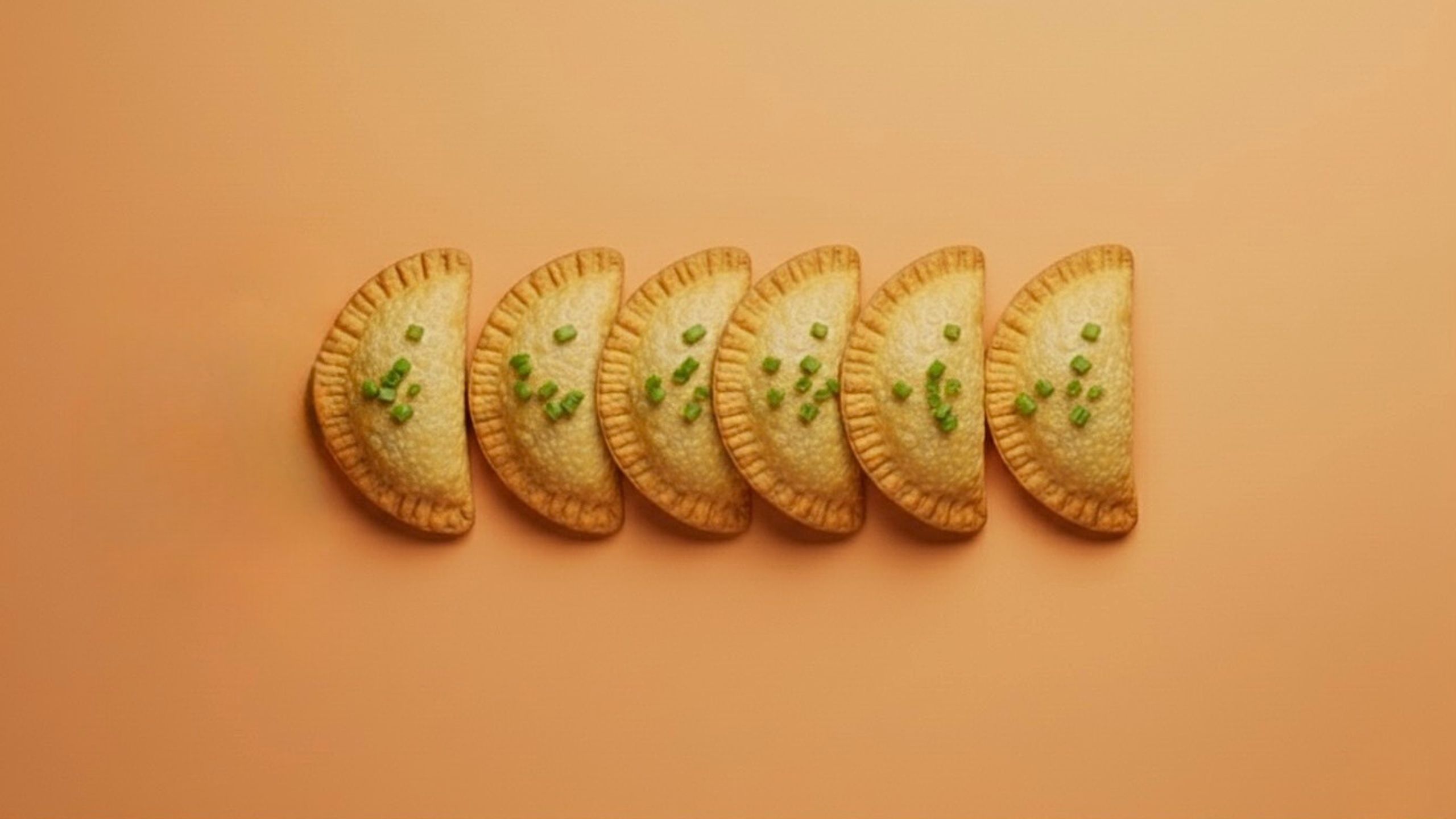 6 empanadas on an orange tabletop